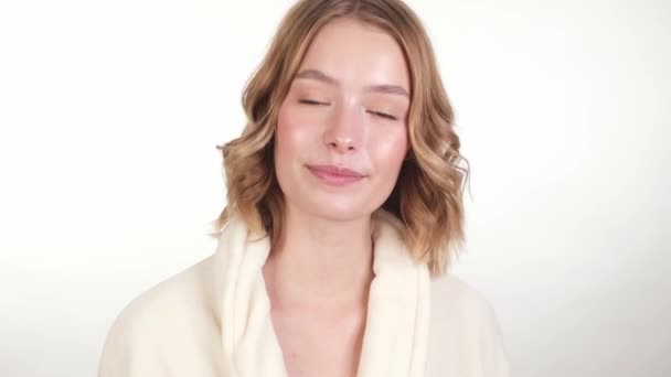 Mooi teder jong meisje in een witte jas met schone frisse huid poseren voor de camera. Schoonheidsgezicht. Huidverzorging. — Stockvideo