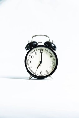Beyaz arkaplanda izole edilmiş siyah bir alarm saati
