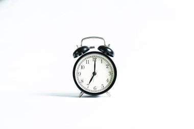 Beyaz arkaplanda izole edilmiş siyah bir alarm saati