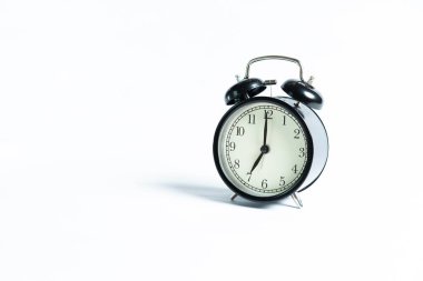 Beyaz arkaplanda izole edilmiş siyah bir alarm saati