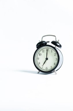 Beyaz arkaplanda izole edilmiş siyah bir alarm saati