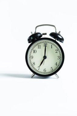 Beyaz arkaplanda izole edilmiş siyah bir alarm saati