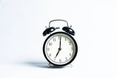 Beyaz arkaplanda izole edilmiş siyah bir alarm saati