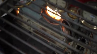 Bir işçi, kömürlü buhar gemisinin motoruna kömür yerleştiriyor.