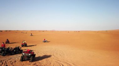 İnsanlar Dubai çölünde dörtlü bisikleti ya da ATV 'yi seviyor.