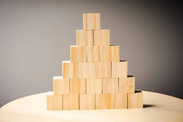 Wooden blocks arranged in stacks on grey background