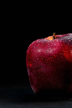 Siyah arka planda izole edilmiş taze ve lezzetli kırmızı elma, elma üzerinde su damlacıkları, seçici odak