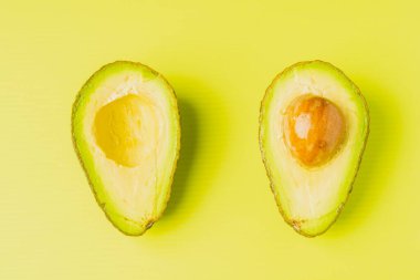 Yeşil arka planda ikiye bölünmüş bir avokado.