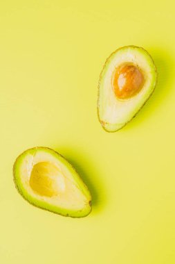 Yeşil arka planda ikiye bölünmüş bir avokado.