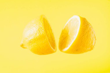 Sarı arka planda yüzen dilimlenmiş limon