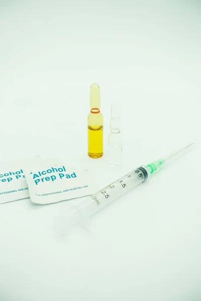 Medication ampoules for Intravenous injections on a wooden background with empty syringe and alcohol swab, medical concept