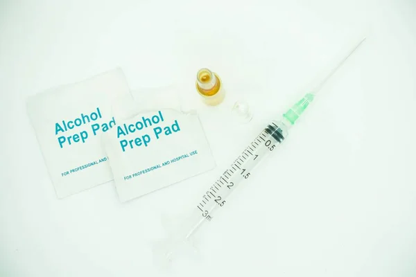 Medication ampoules for Intravenous injections on a wooden background with empty syringe and alcohol swab, medical concept