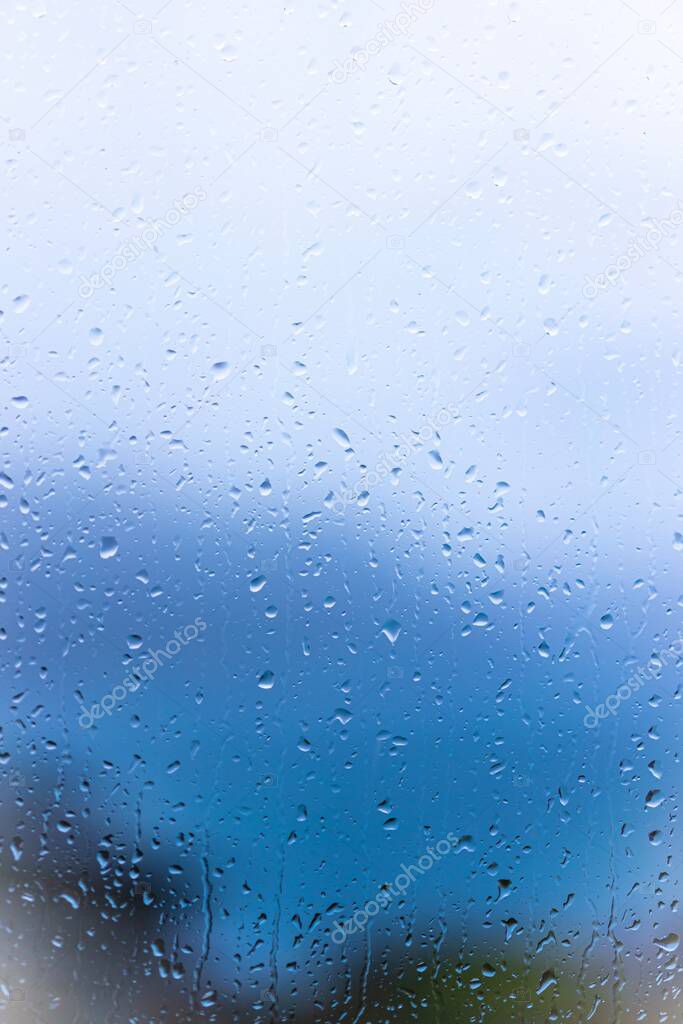 Raindrops on window glass with blur background