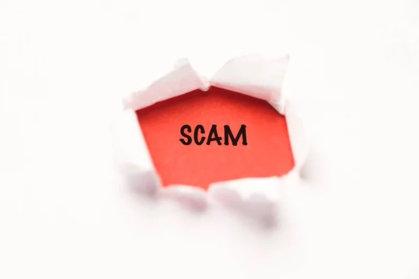 引き裂かれた紙の背景にScamの文言 — ストック写真