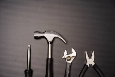 Çekiç, pense, ingiliz anahtarı, tornavida ve mezura da dahil olmak üzere bir takım aletlerin düz bileşimi
