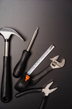 Çekiç, pense, ingiliz anahtarı, tornavida ve mezura da dahil olmak üzere bir takım aletlerin düz bileşimi