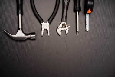 Çekiç, pense, ingiliz anahtarı, tornavida ve mezura da dahil olmak üzere bir takım aletlerin düz bileşimi