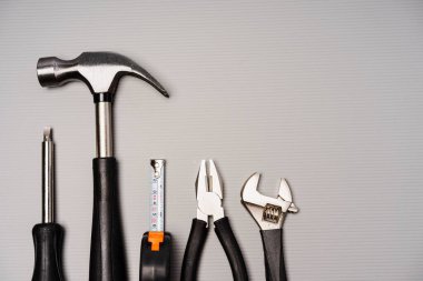 Çekiç, pense, ingiliz anahtarı, tornavida ve mezura da dahil olmak üzere bir takım aletlerin düz bileşimi