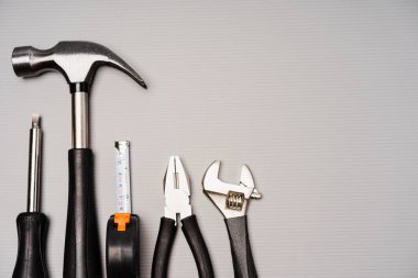 Çekiç, pense, ingiliz anahtarı, tornavida ve mezura da dahil olmak üzere bir takım aletlerin düz bileşimi