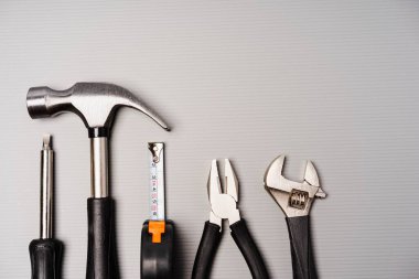 Çekiç, pense, ingiliz anahtarı, tornavida ve mezura da dahil olmak üzere bir takım aletlerin düz bileşimi