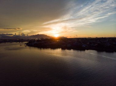Günbatımında Sarawak Nehri 'nin manzaralı manzarası. Arka planda Gunung (dağ) Serapi.