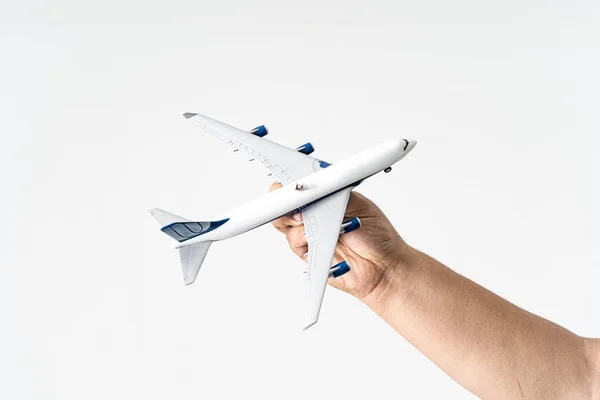 A mans hand holding a miniature aeroplane