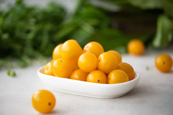 Pequenos tomates cereja amarelos com ervas — Fotografia de Stock