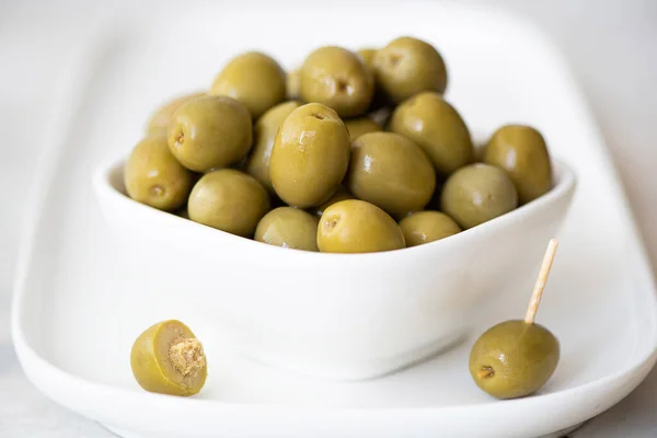 Olivenkonserven mit Kernen in einer weißen Schüssel — Stockfoto