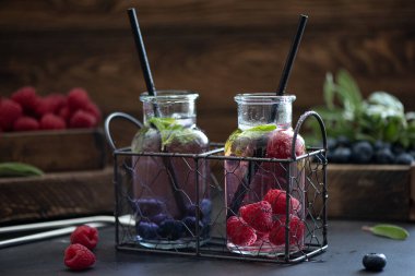 Küçük şişelerde buzlu ahududu ve yabanmersini limonatası.