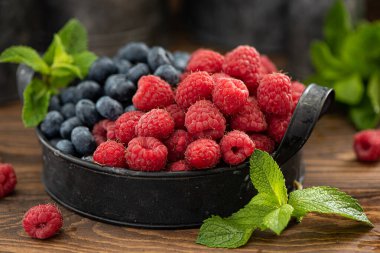 Demir tabakta taze yaban mersini ve ahududu.