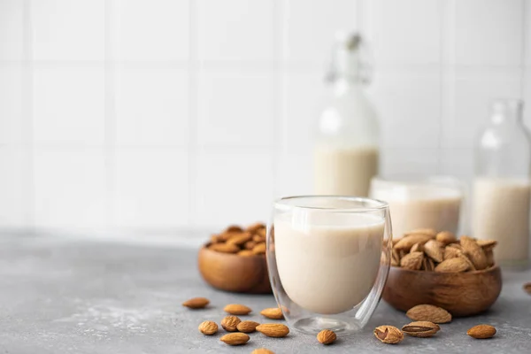 homemade almond milk in glasses and bottle ob table