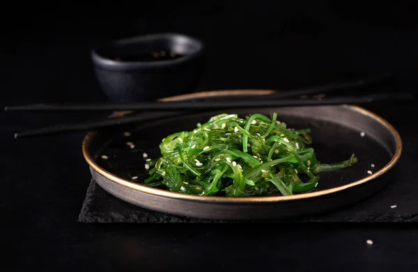 seaweed, sesame and soy sauce salad on a black plate