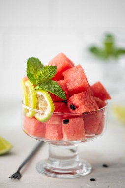 Küçük olgun karpuz parçaları kireç ve nane şekerli cam bir kasede