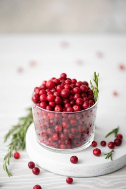 Olgun yaban mersinleri beyaz bir tahtanın üzerinde cam bir kasede