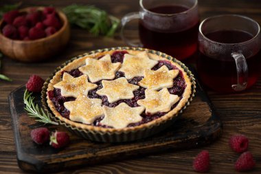 Ev yapımı ahududu turtası ahşap bir masada hamur parçasından yapılır.