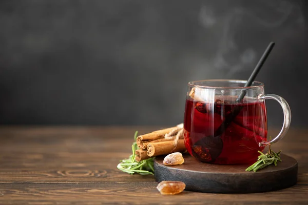 hot hibiscus tea with cinnamon and sugar on a wooden table