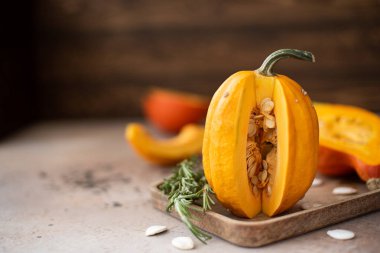 Tahta masadaki tohumlarla olgunlaşmış sarı balkabağı, yakın çekim.