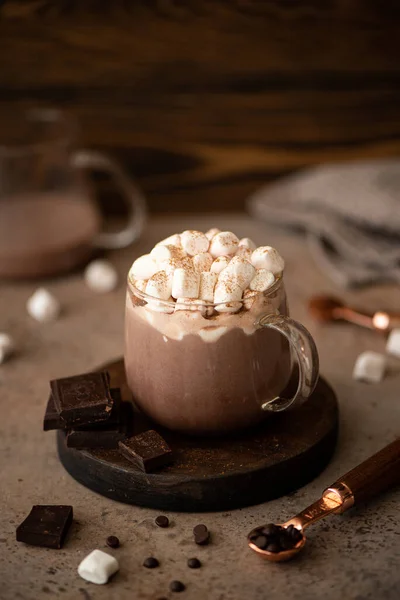hot sweet chocolate cocoa with marshmallow and cinnamon in a glass mug on a wooden background