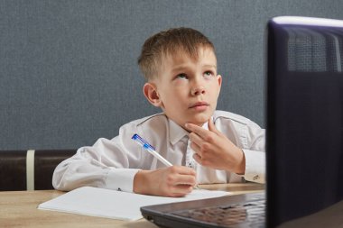 Çocuk ev ödevi olarak dizüstü bilgisayar kullanıyor. Covid-19 sırasında çocuk evde kalıyor. Sosyal Uzaklık Öğrenimi ve Çevrimiçi Eğitim Konsepti