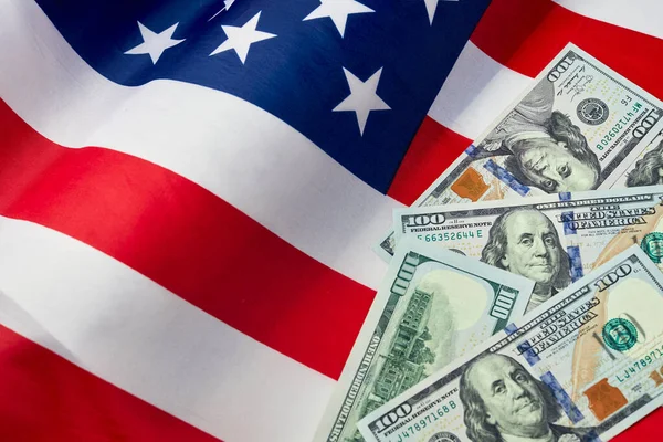 Amerikan bayrağını ve dolar nakitini kapatın. Bir dolar banknot ve arka planda Birleşik Devletler bayrağı. ABD Ekonomisi