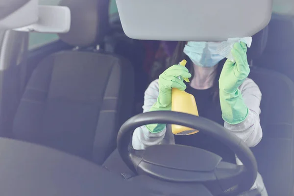 Samice rozpylają środki odkażające i chusteczki antyseptyczne do dezynfekcji samochodu. Czystość i opieka zdrowotna podczas stosowania wirusa Corona, COVID-19. — Zdjęcie stockowe
