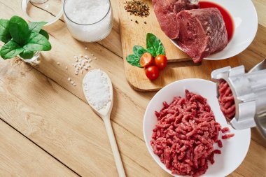 Chopped raw meat and ground beef . The process of preparing forcemeat by a meat grinder. Top view. clipart