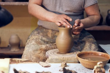 Potter işte. Atölye. Bir çömlekçinin elleri çemberin üzerinde kavanoz oluşturuyor..