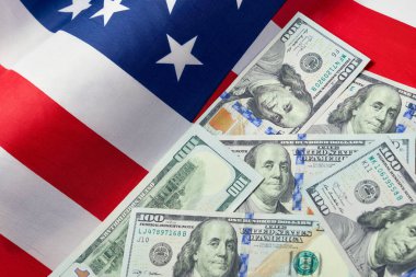 Amerikan bayrağını ve dolar nakitini kapatın. Bir dolar banknot ve arka planda Birleşik Devletler bayrağı. ABD Ekonomisi