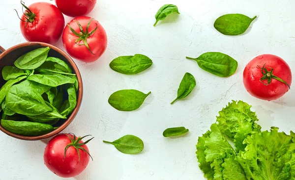 Fresh grape tomatoes with salad and spinach Leaves on white background. Vegan veggies diet food. Herb, tomatoes, cooking concept.