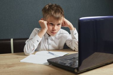 Çocuk ev ödevi olarak dizüstü bilgisayar kullanıyor. Covid-19 sırasında çocuk evde kalıyor. Sosyal Uzaklık Öğrenimi ve Çevrimiçi Eğitim Konsepti