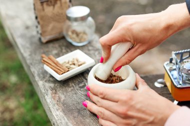 Sıcak bir şeyler içelim. Doğada baharatlı kahve pişirme süreci. Arka plan - kamp ve orman.