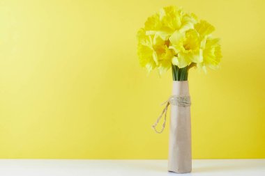 Bir buket sarı bahar çiçeği. Bir deste narsisli el işi kâğıdı ve Anneler Günü için tebrik kartı.