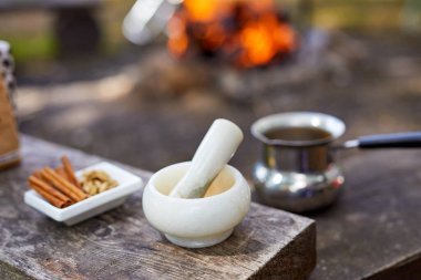 Sıcak bir şeyler içelim. Doğada baharatlı kahve pişirme süreci. Arka plan - kamp ve orman.