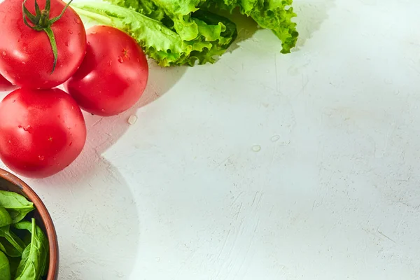 Fresh grape tomatoes with salad and spinach Leaves on white background. Vegan veggies diet food. Herb, tomatoes, cooking concept.